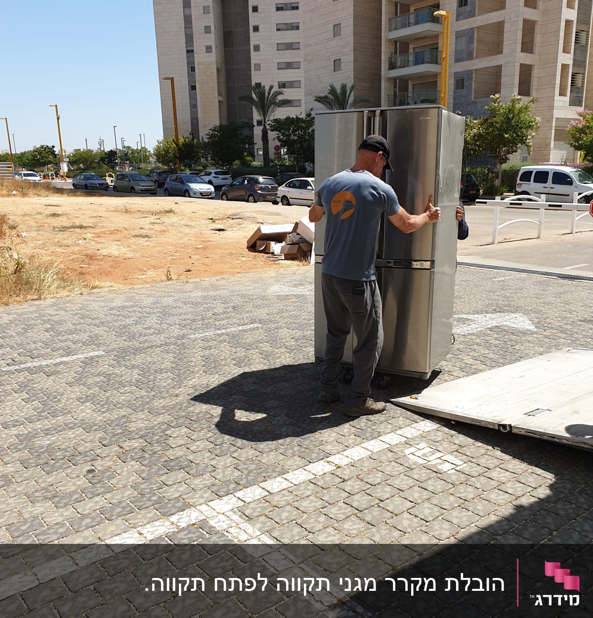 אדם מזיז מקרר על רמפה בחוץ